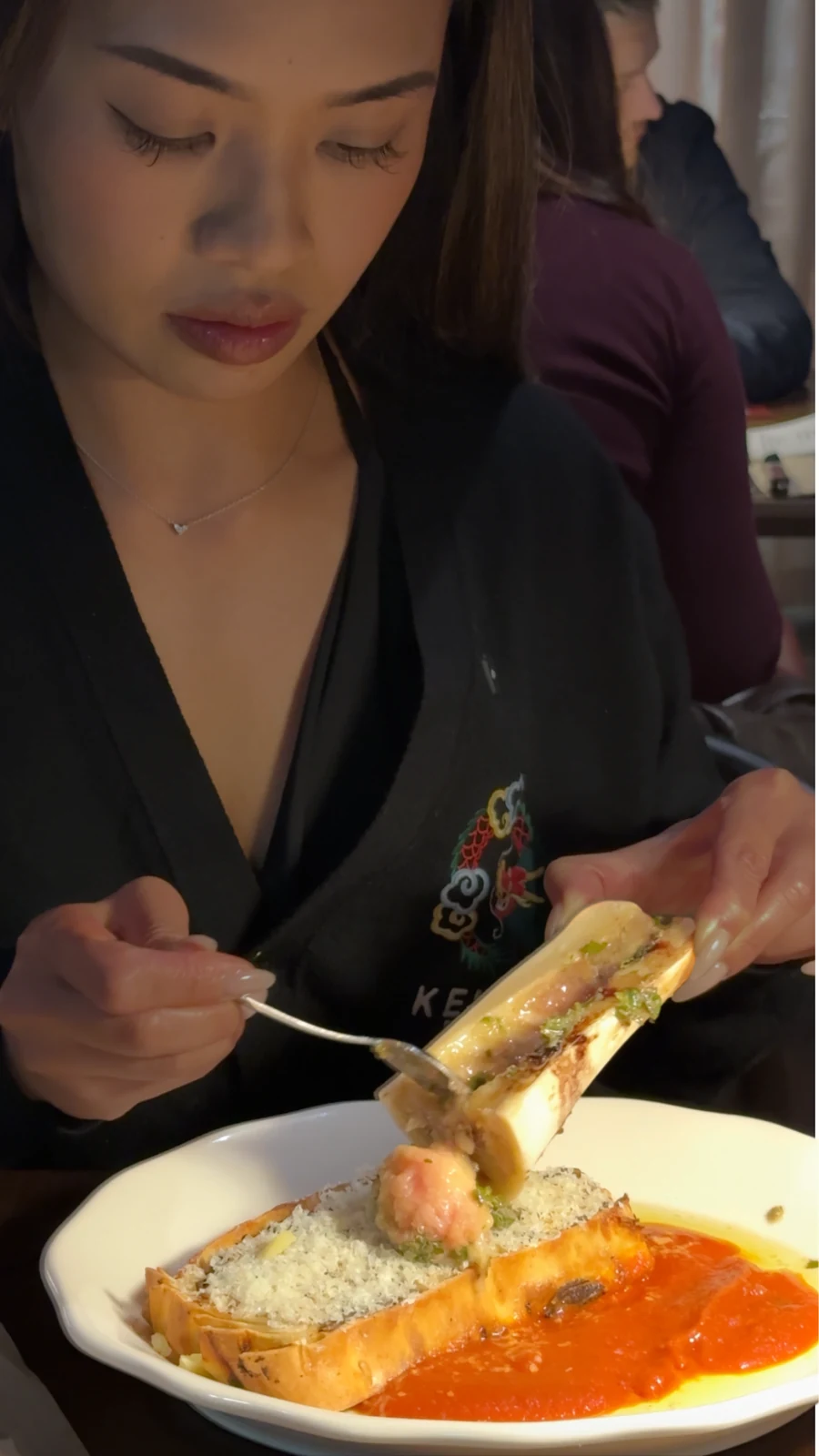 Spooning roasted bone marrow over the wagyu brisket lasagne at Common Cuts, Melbourne